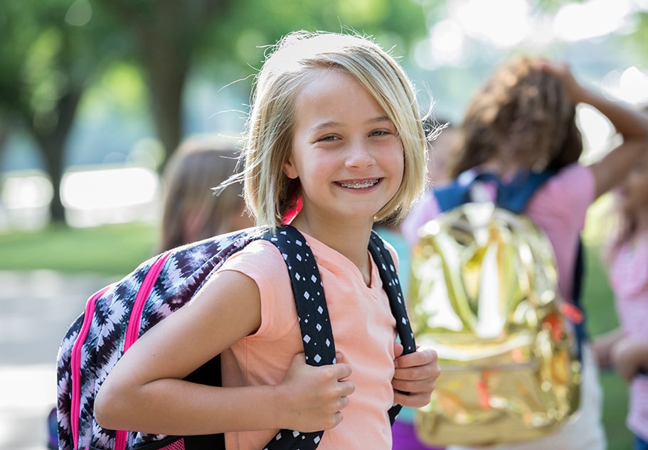 girl smiling with backpack going to destin school
